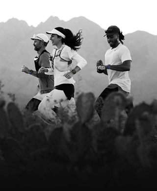 Tre persone che corrono in un paesaggio di montagna, tutte con Apple Watch Ultra 3 al polso